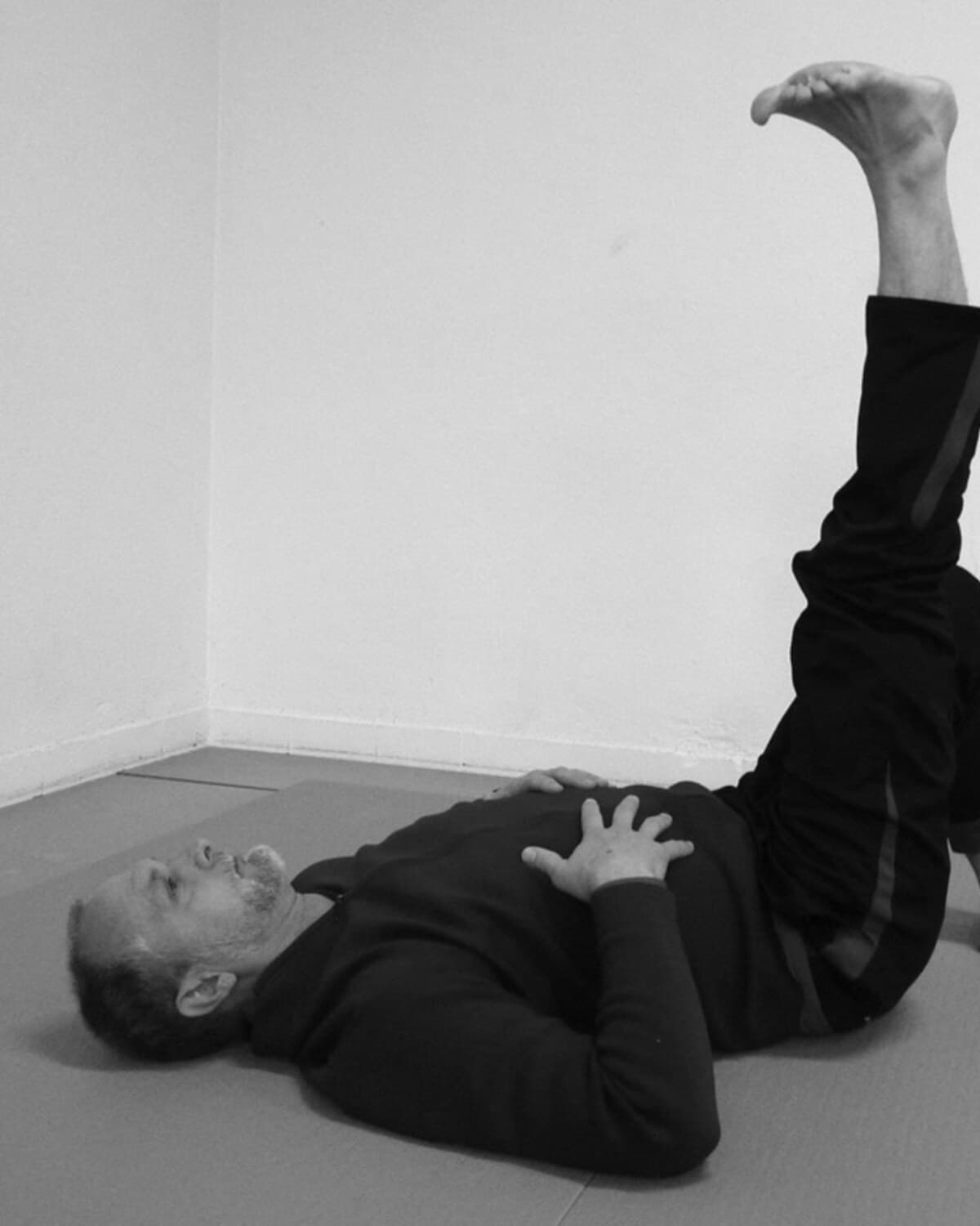 Allen Pittman liegt am Boden, ein Bein angehoben, während einer Wisdom-of-the-Body-Studie